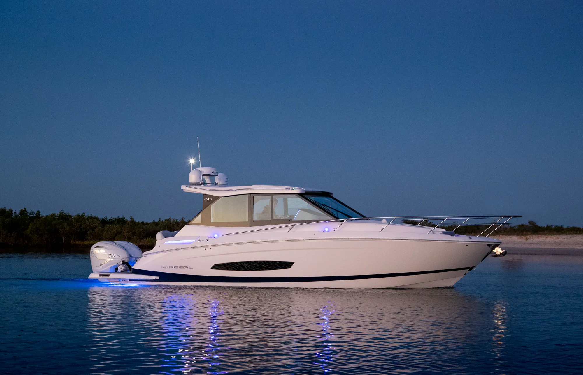 Regal 36 XO anchored at dusk with blue underwater lights