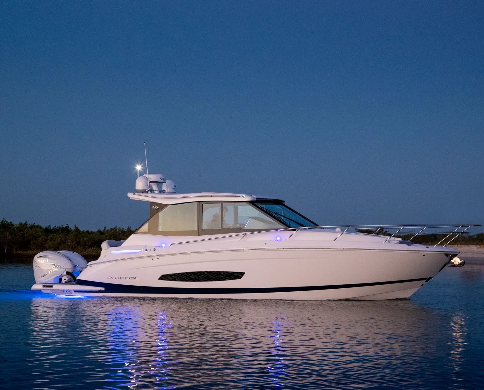Regal 36 XO anchored at dusk with blue underwater lights