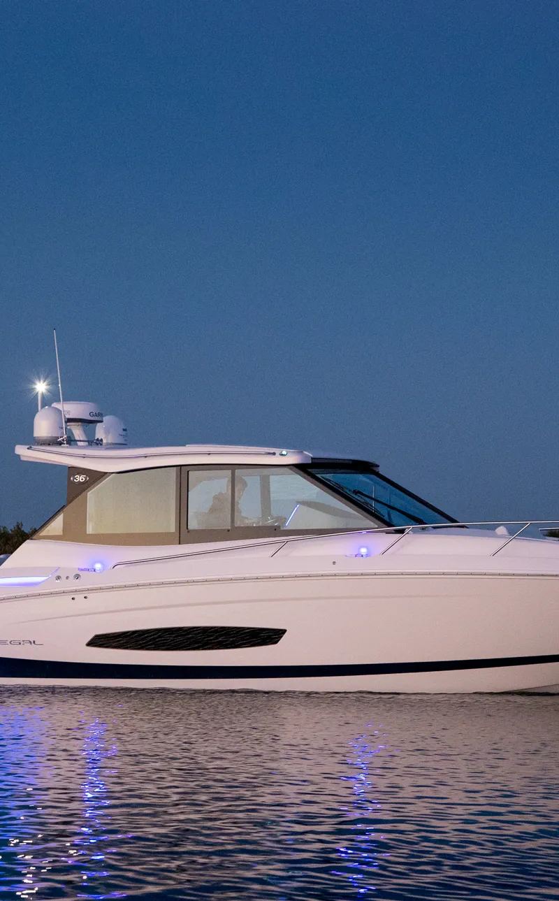 Regal 36 XO anchored at dusk with blue underwater lights