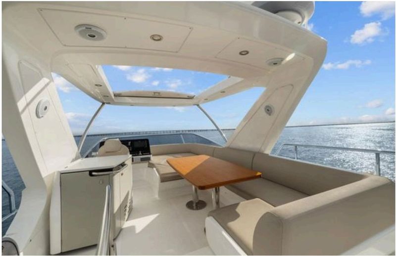 Flybridge seating area with bimini and C-shaped sofa