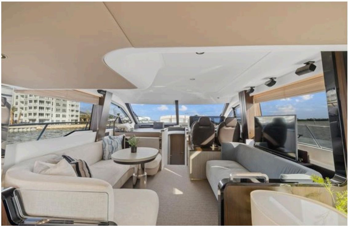 Main salon with white sofas, large windows and electric lift table